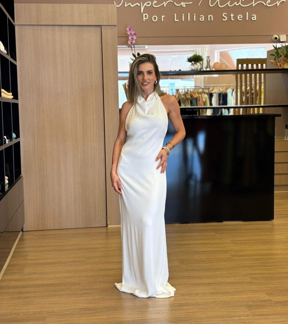 Vestido longo branco de frente única, com caimento fluido, costas abertas com amarração e modelagem elegante.