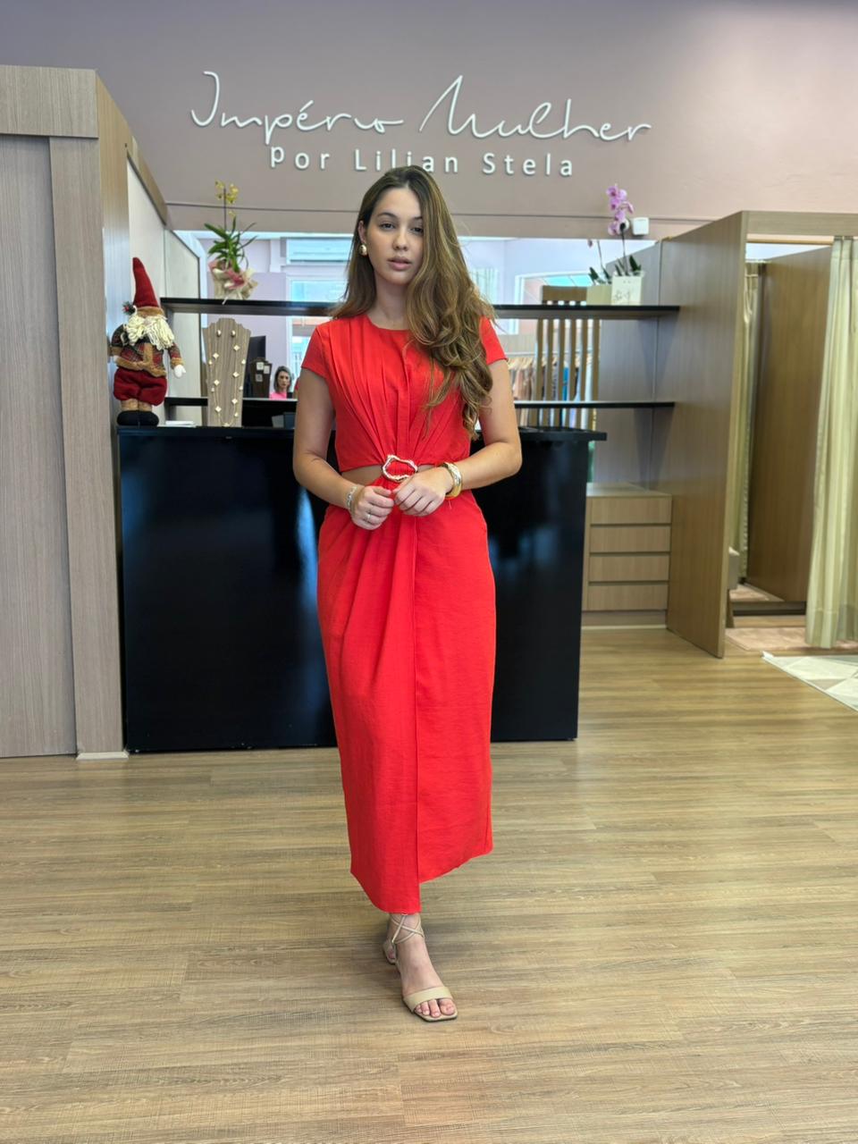 Modelo veste vestido midi vermelho com mangas curtas.