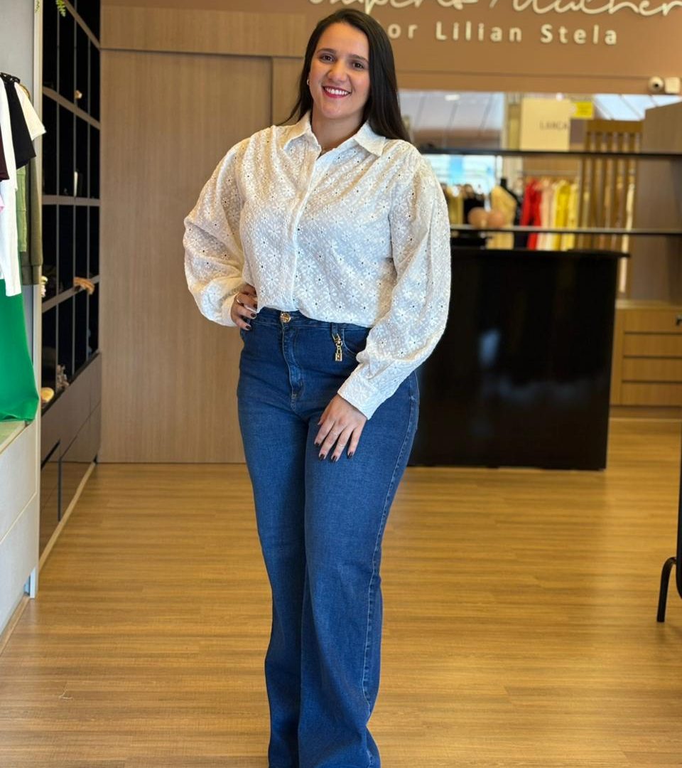 Modelo usando camisa branca em laise de manga longa e bordada.
