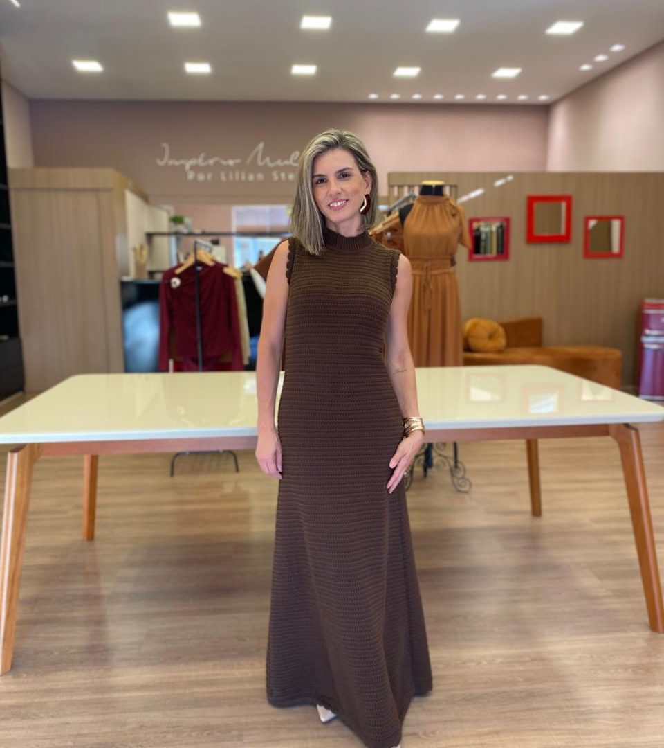 Vestido super midi marrom em tricot canelado com gola alta, modelagem reta e elegante, ideal para looks sofisticados e confortáveis.