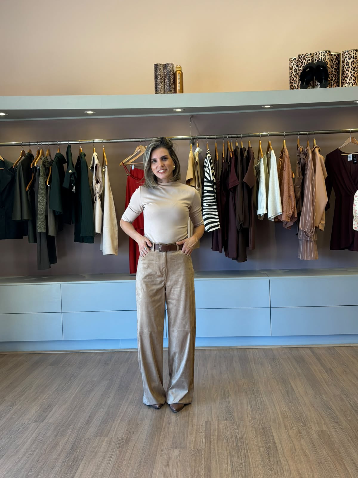 Modelo usando calça feminina em suede camel de modelagem reta e cintura alta