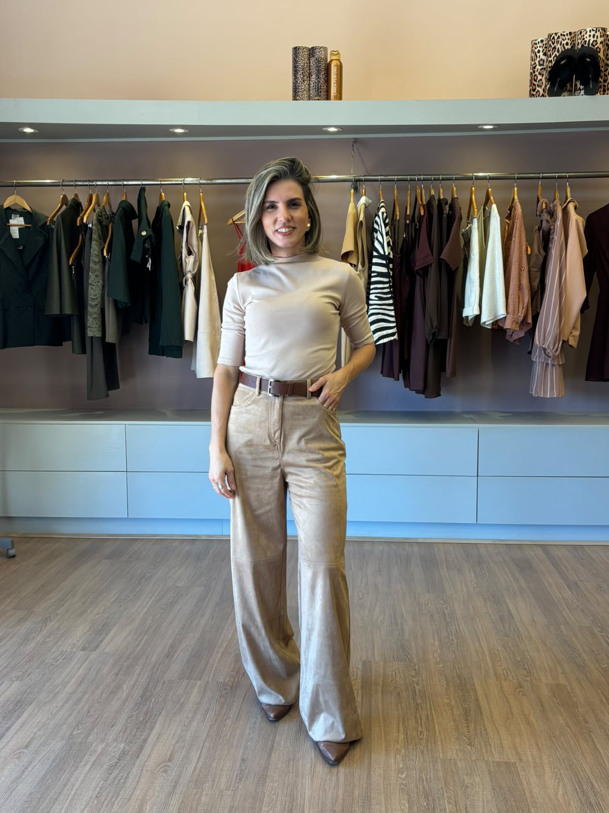Modelo usando calça feminina em suede camel de modelagem reta e cintura alta