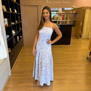 Modelo vestindo vestido longo com estampa floral em relevo, alças finas e saia fluida.