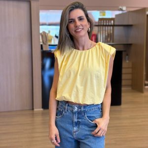 Modelo vestindo blusa sem mangas em tecido leve.