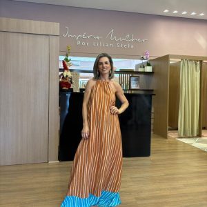 Vestido super midi feminino listrado em tom terroso, com decote frente única, costas abertas com amarração e detalhe em contas, modelagem fluida e barra contrastante azul.