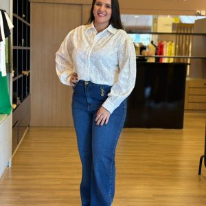 Modelo usando camisa branca em laise de manga longa e bordada.