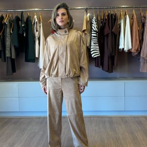 Modelo usando jaqueta feminina em suede camel com gola alta e modelagem ampla, combinada com calça reta em suede